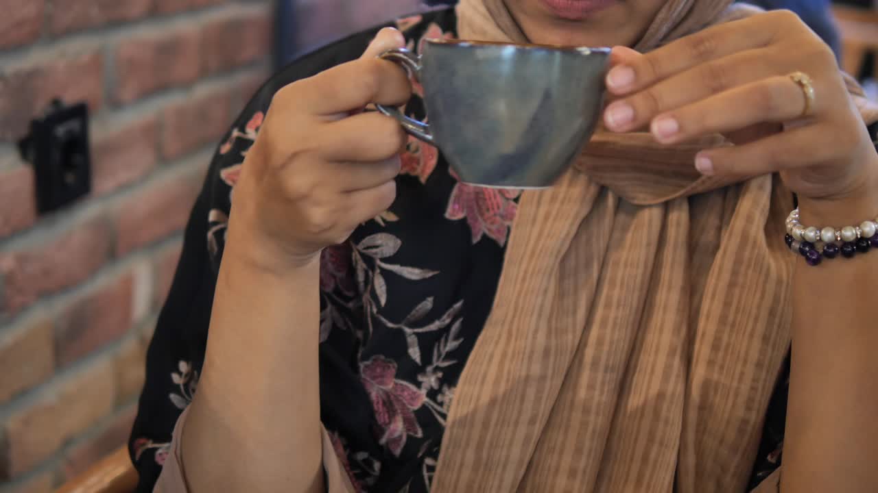 Una mujer bebiendo café.