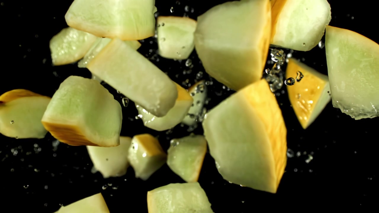 Fresh Melon Chunks and Water Splashing in Slow Motion