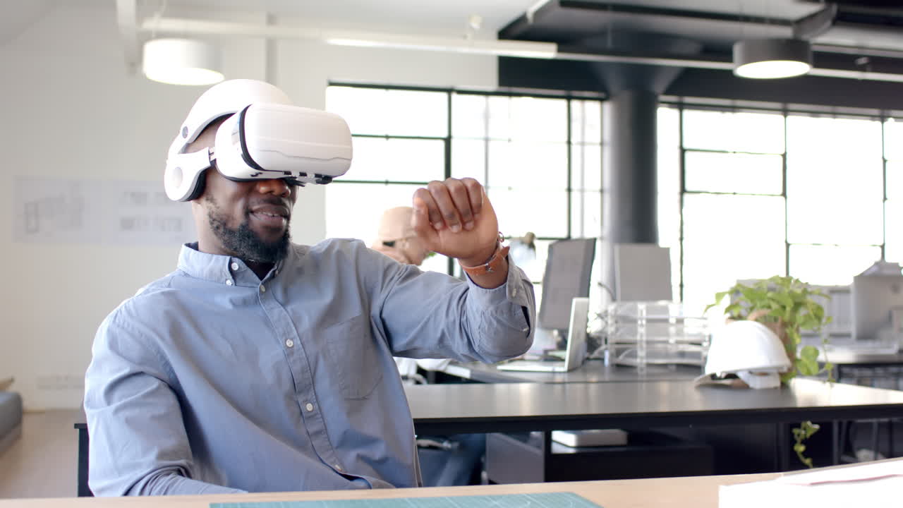 Using VR headset, man interacting with virtual environment in modern office
