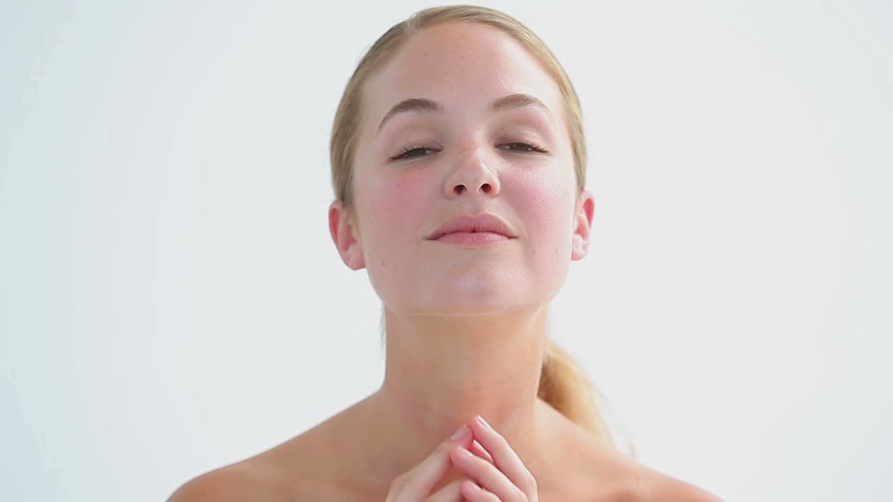 mujer rubia sonriente frotando sus dos mejillas