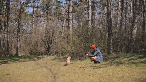 Mujer-Joven-Con-Pelo-Corto-Juega-Con-Su-Perro-En-El-Campo