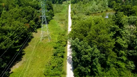 drone footage of a rural trail and trees, and some small ponds as well