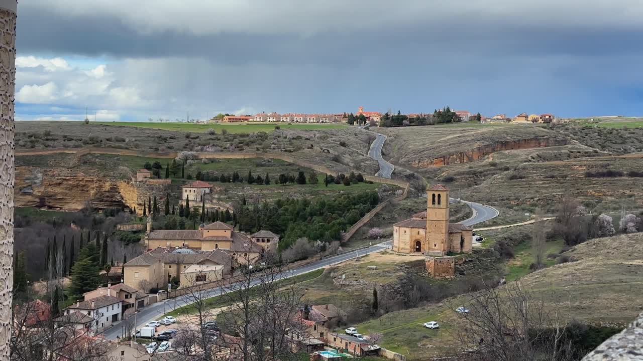 Scenic Segovia landscape with winding road and rural buildings