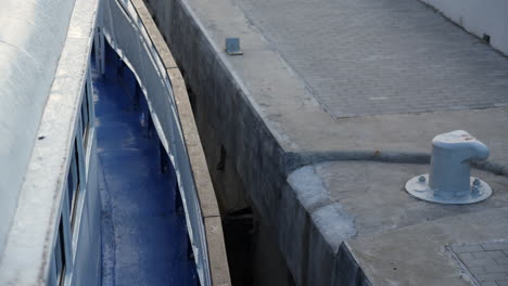 close-up view of a ship docked next to a pier with a mooring bollard