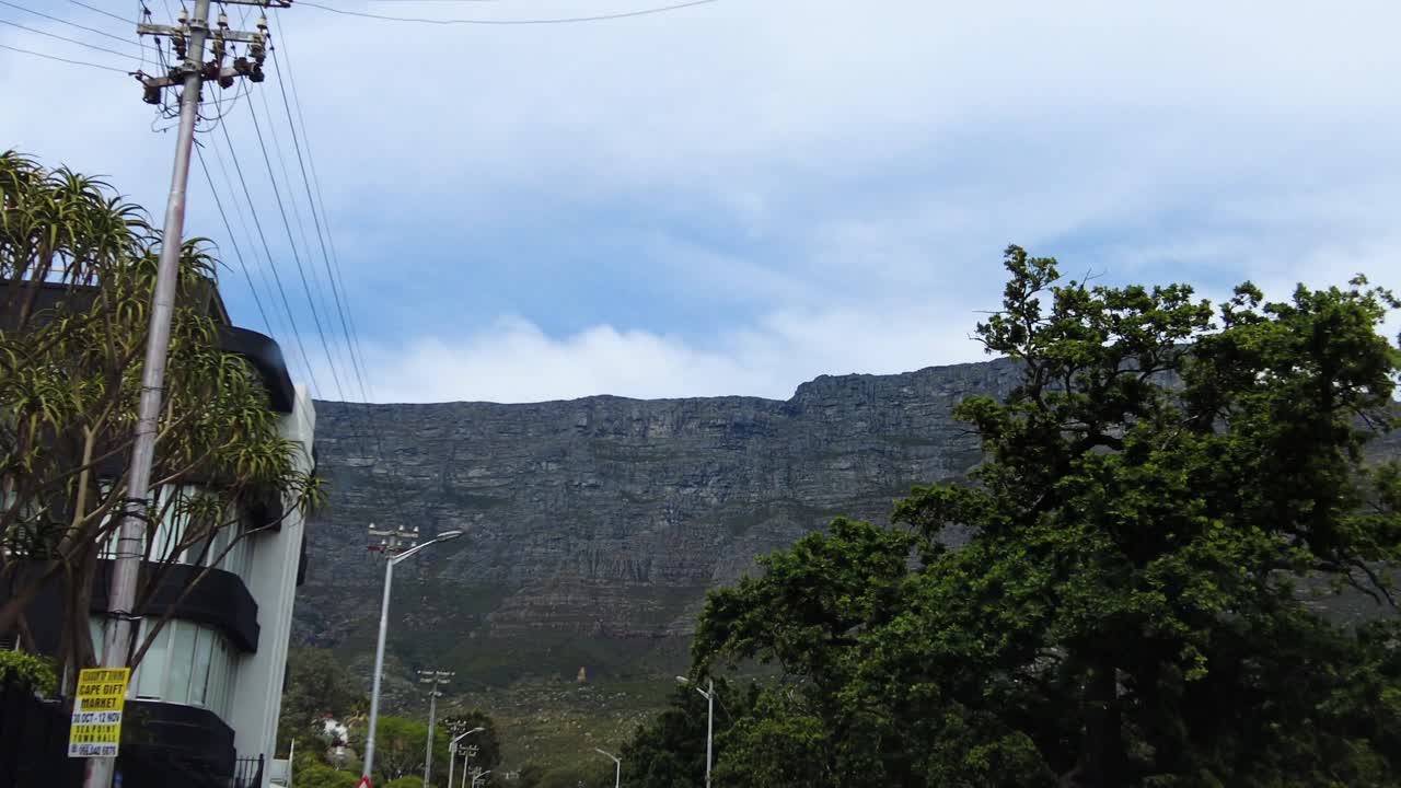 conduciendo en la carretera mirando la cordillera de las montañas de la mesa a través de ciudad del cabo, sudáfrica