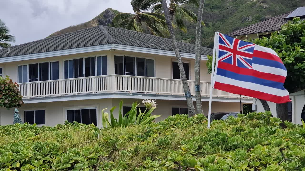 Hawaii State Flag With British Union Jack Waving in Front of Beachfront Villa on Lanikai Beach, Oahu Island, USA