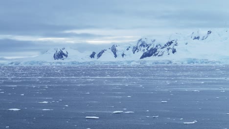 aerial drone shot of antarctica landscape, glacier and mountain scenery on the antarctic peninsula in the southern ocean, winter seascape of ocean, snow and ice in cold windy weather