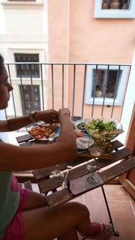 woman having dinner on a balcony with city view