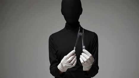 person in black mask with medical tools