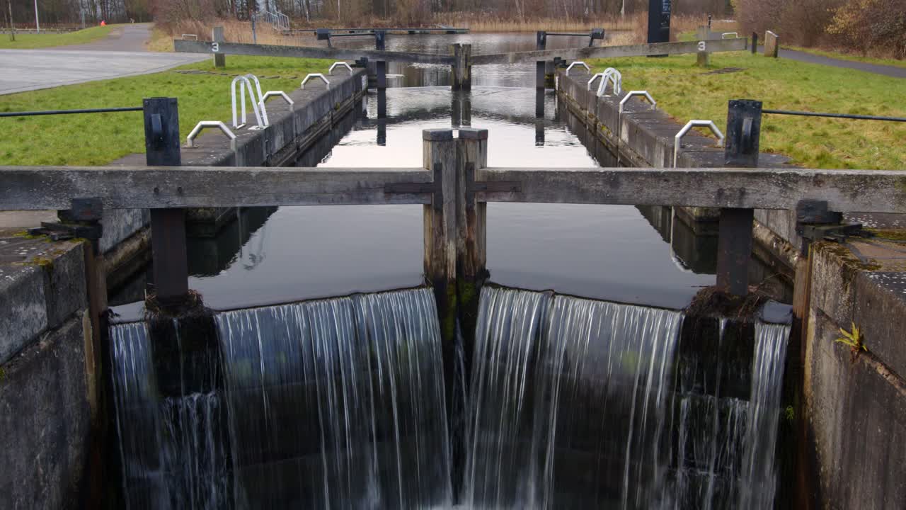 медленно приближайтесь к шлюзовым воротам канала форта и клайд с водой, протекающей по каналу форта и клайда.