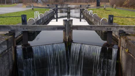 slow zoom in on the lock gates of the forth and clyde canal with water flowing over on the forth and clyde canal