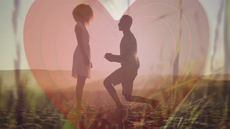 animación del corazón latiendo sobre el hombre proponiendo a la mujer en el fondo