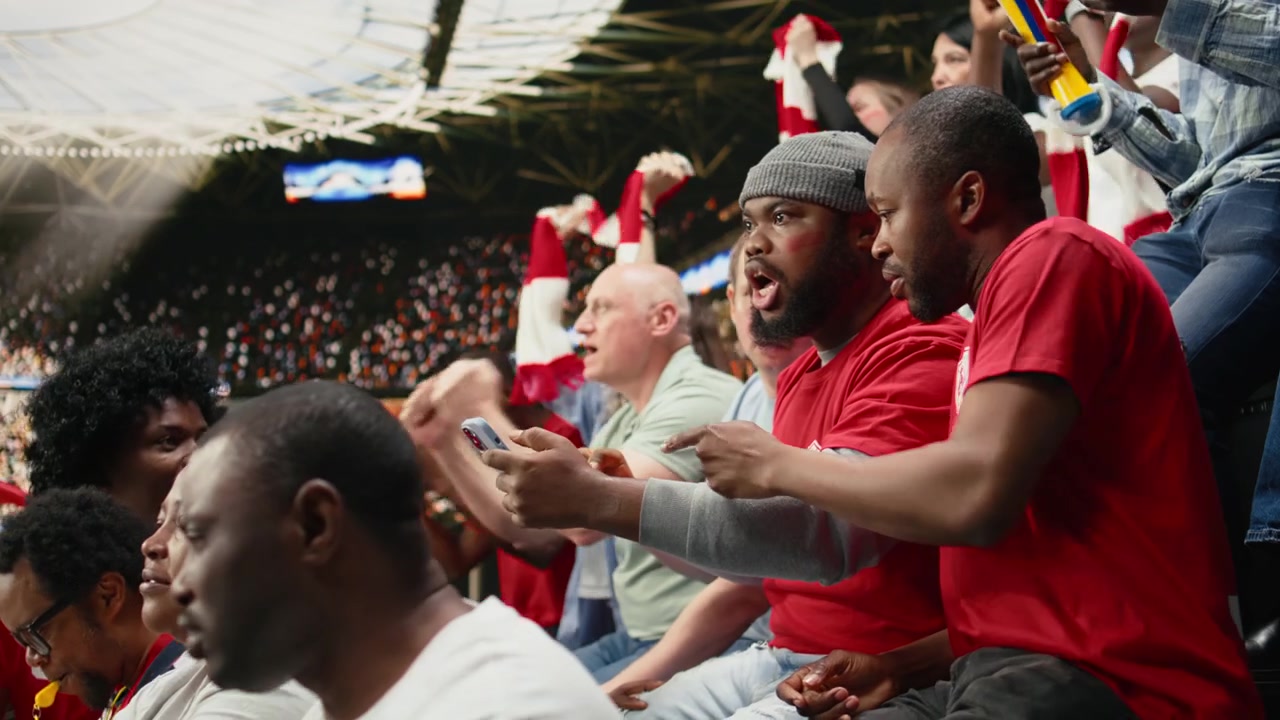 Passionate black fans following live betting odds on smartphone