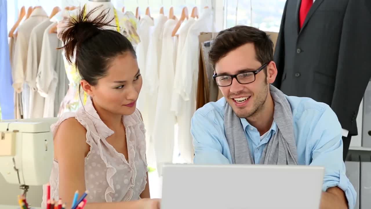 equipo de diseño trabajando felizmente juntos en el portátil