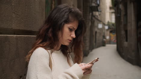 Mujer-Joven-Usando-Un-Teléfono-Inteligente-En-La-Calle