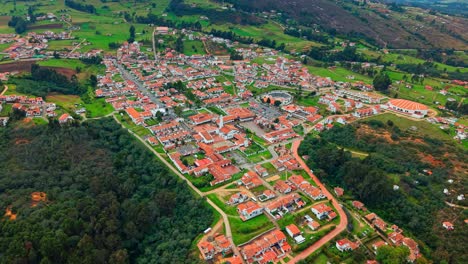 aerial flyover establishing the town of guatavita in cundinamarca colombia, a colonial tourist town with ancient architecture and tile roofs in a natural environment.