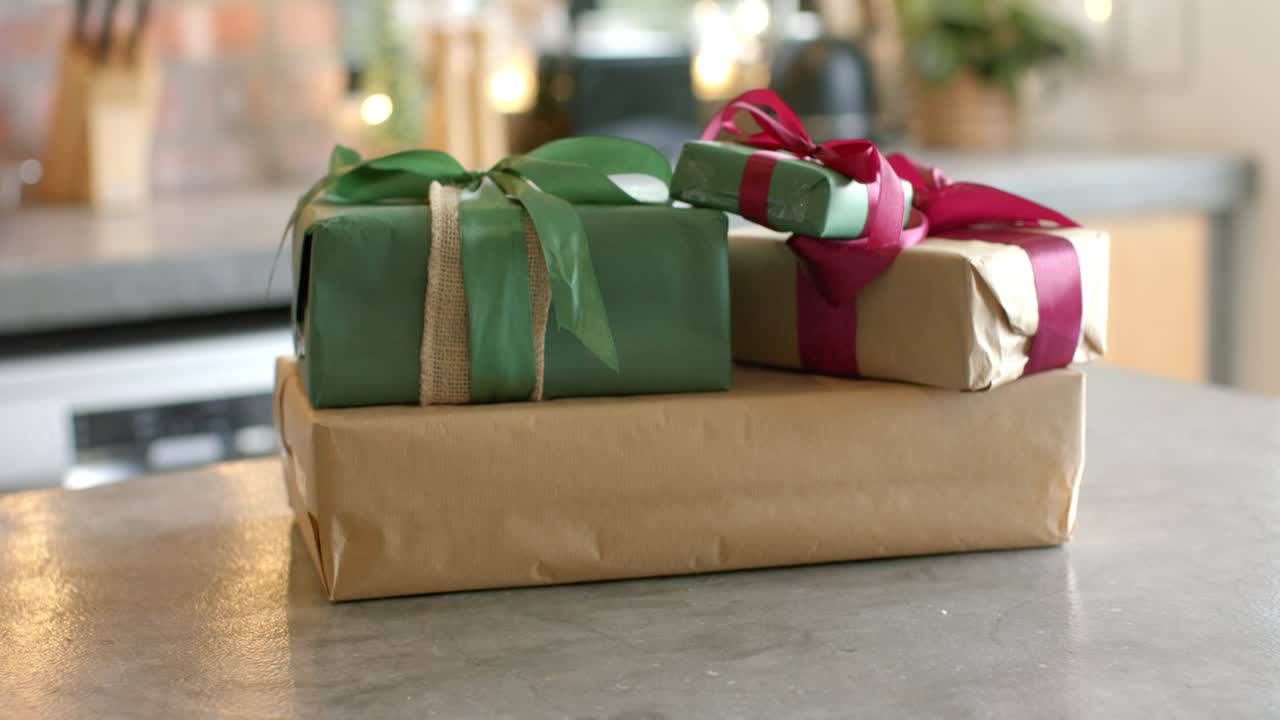Lo spostamento della messa a fuoco dell'obiettivo rivela tre confezioni regalo sul piano di lavoro della cucina per evidenziare i dettagli dell'incartamento