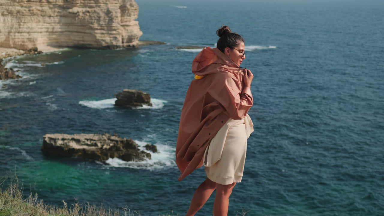 Mujer disfrutando de la vista desde acantilados costeros