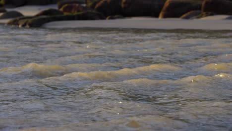 Heller-Wasserfluss-Am-Strand,-Der-Bei-Sonnenuntergang-Ins-Meer-Fällt