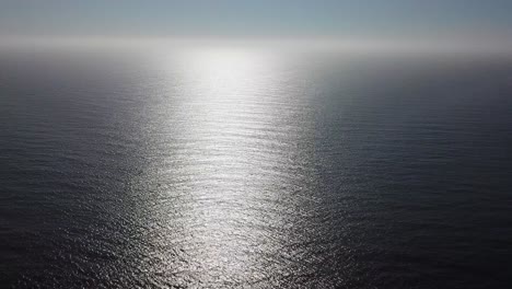 aerial shot of ocean in suns reflection