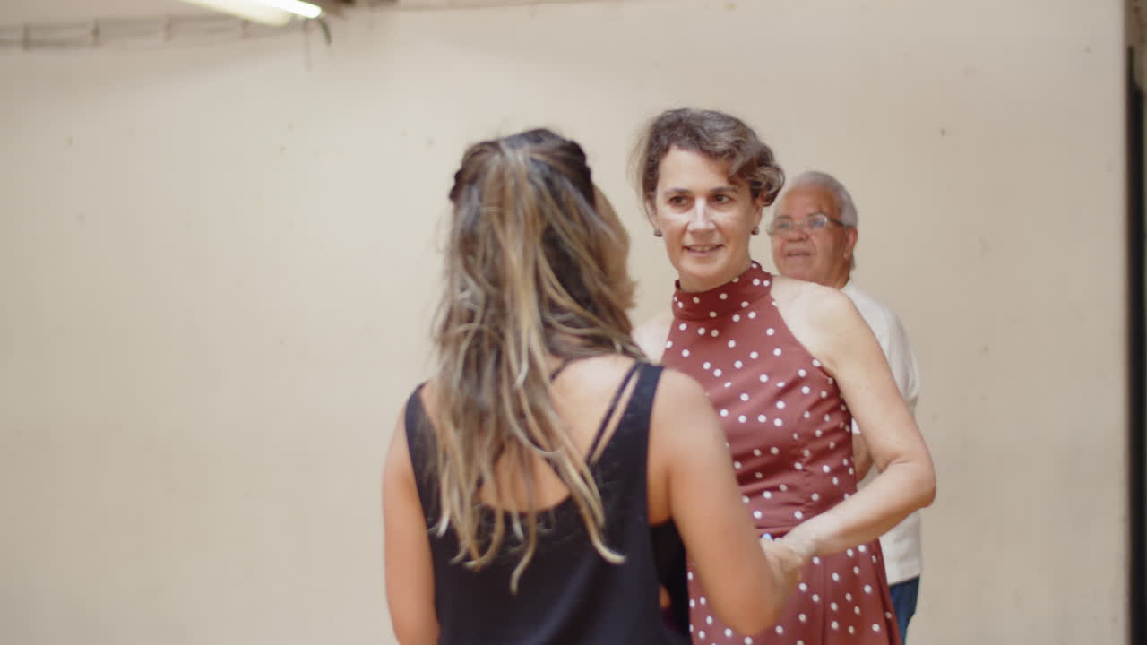 profesor bailando con mujer asistiendo a clase