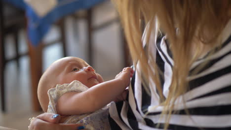 Mother-holding-baby-daughter-in-hands-and-looking-at-her