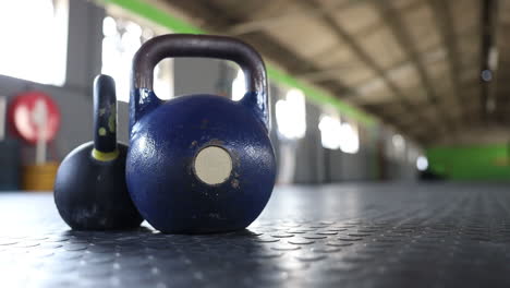 tomas panorámicas de pesas rusas en el piso de un gimnasio