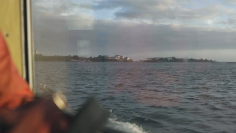 Window-shot-from-a-ferry-passing-by-Suomenlinna-island,-on-a-autumn-day,-in-Helsinki,-Uusimaa,-Finland