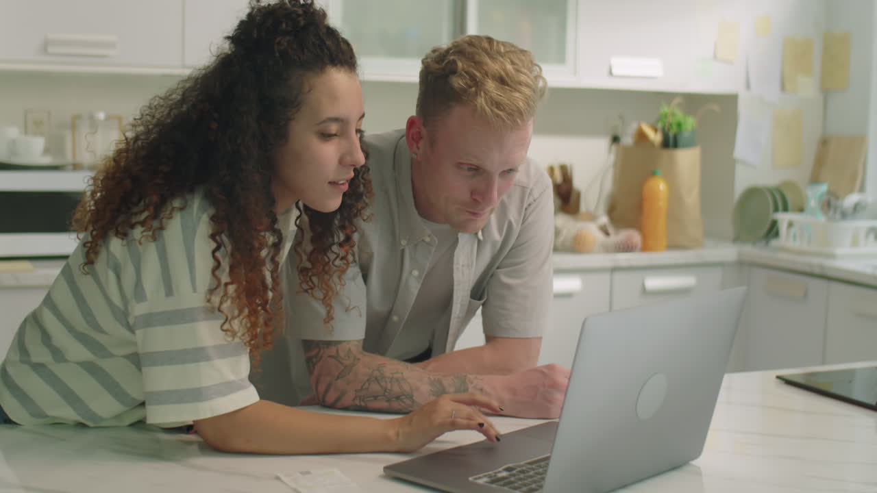 Couple Planning Family Budget with Laptop at Home