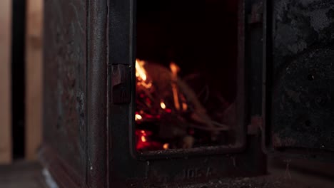 a man's hand is igniting a fire in the wood stove in indre fosen, trondelag county, norway - close up