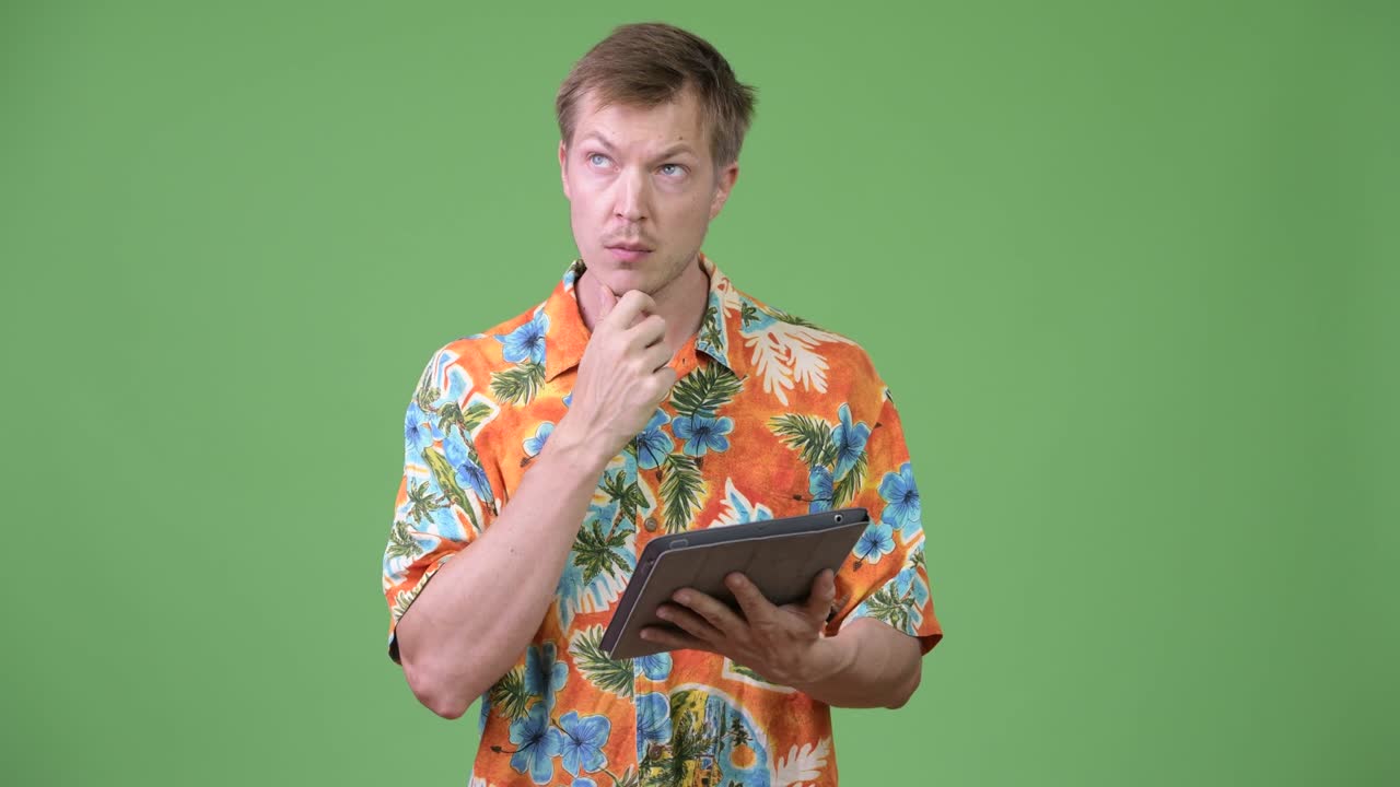 Young handsome tourist man using digital tablet and thinking