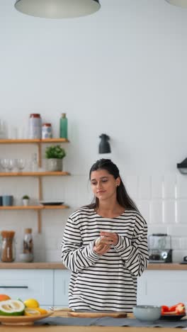 mujer olendo ingredientes en una cocina