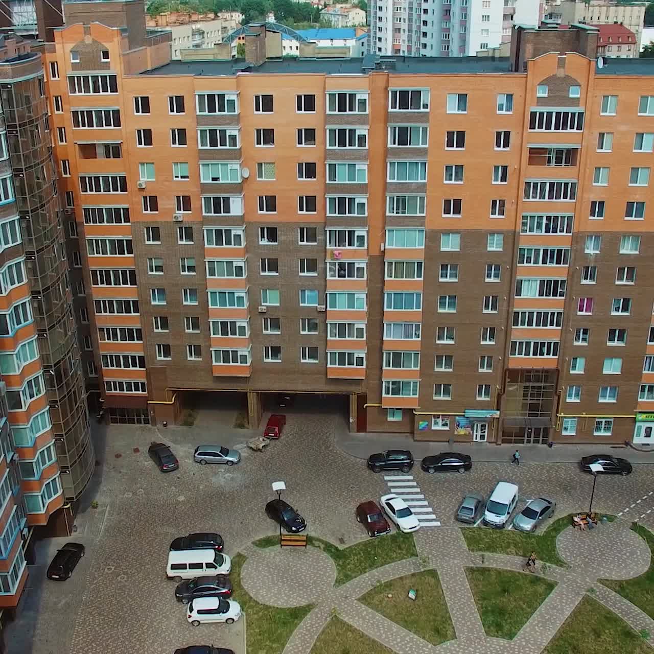 Aerial view of a modern residential apartment complex with courtyard and parked cars
