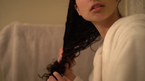 beautiful latina woman runs her fingers through her long dark hear after a shower - slow motion