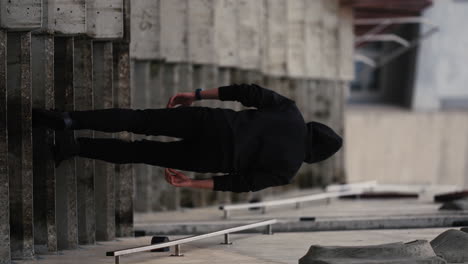 sinister hooded man with his back to the camera climbing the stairs of an alleyway