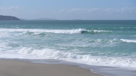 Waves-crashing-gently-on-quiet-sandy-beach