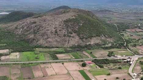 aerial view of a mountainous rural landscape with agricultural fields and road