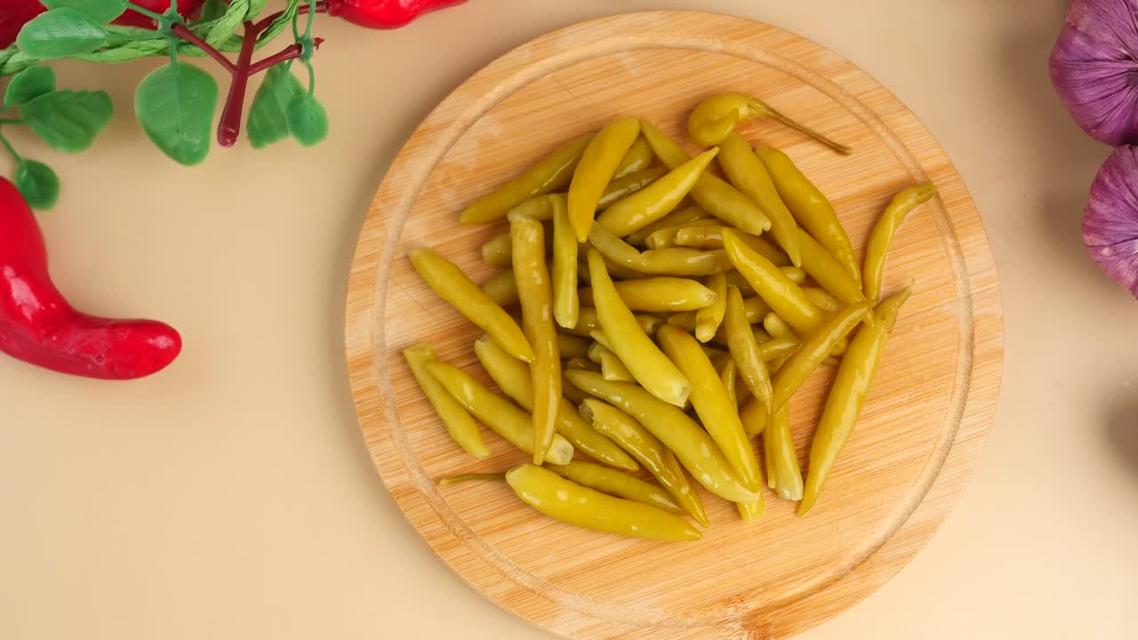 Pickled Green Peppers and Purple Garlic on Wooden Board