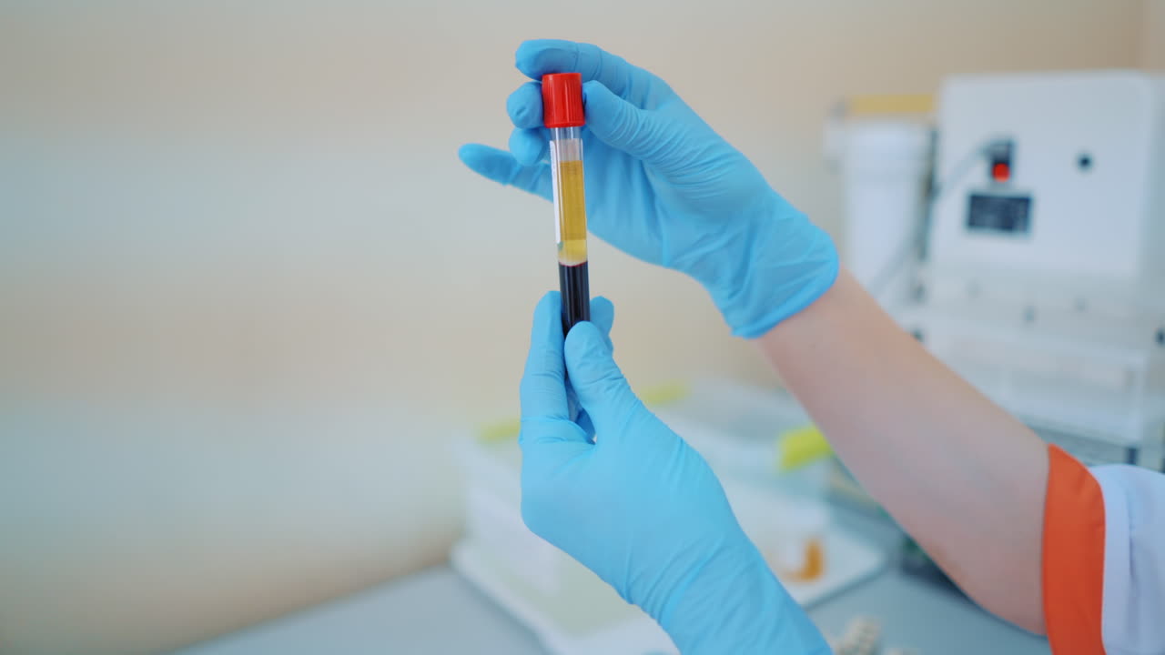 Scientists researching in laboratory. Hand of a scientific taking a blood sample tube