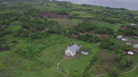 Small-white-church-close-to-Pantai-Mandorak-Sumba-Indonesia-at-sunrise,-aerial