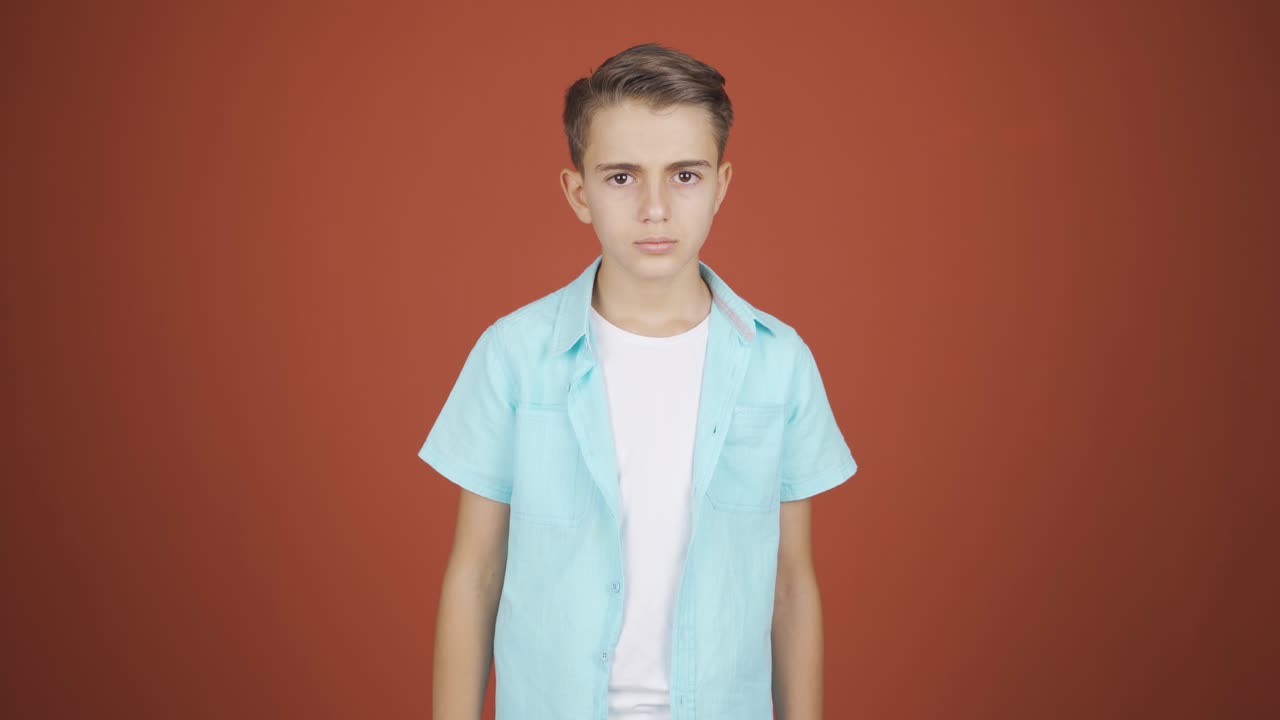 소년은 카메라를 보면서 경고하고 있습니다.