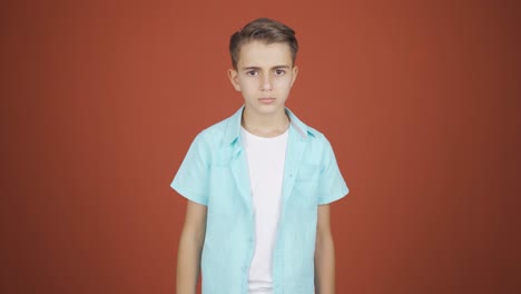 the boy is warning by looking at the camera.