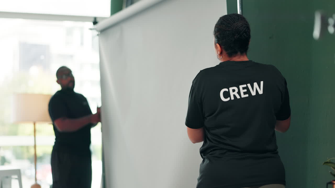 Production crew setting up backdrop for photoshoot