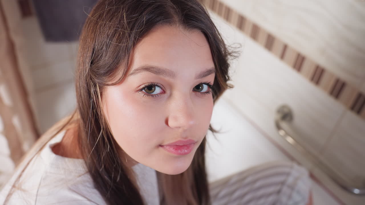 Portrait of miss seated in bathtub, side profile in bathroom, long brunette hair, calm focused expression, soft light on skin, visible rail and tiles, indoor scene of care and hygiene during bathing