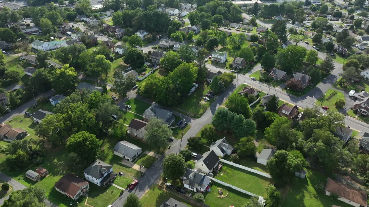 Quaint Houses and Homes in American Suburb with green grassy front yard. Beautiful sunny day in summer season. Single Family Houses in suburbia of american town. Aerial top down