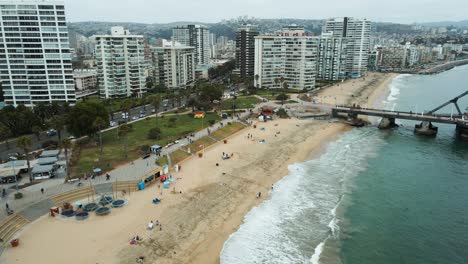 vista aérea pasando por encima de la playa el sol en la ciudad de viña del mar en un día nublado