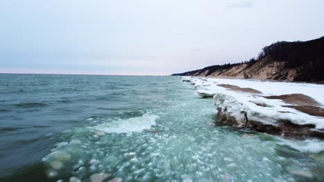 4k drone flies along frozen shoreline