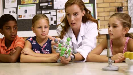 Teacher-explaining-a-kids-about-molecular-model-in-laboratory