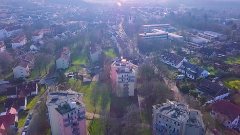 drone shot of poor rural northern germany district during bright sunny day in germany,europe. three tower blocks rising in the sky in outside the city.