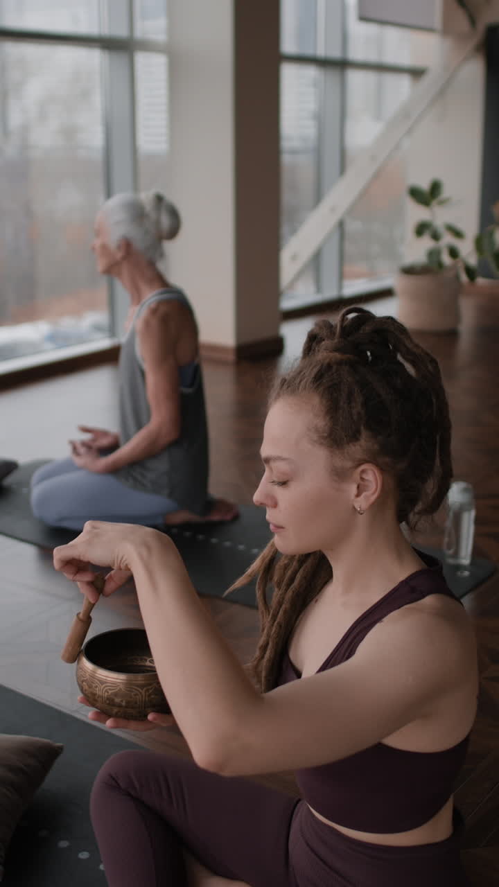 Women Meditating with Singing Bowls in Yoga Studio